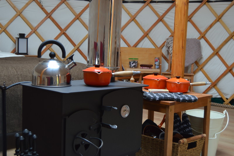 the yurt contains a log burning stove which incorporates a hotplate and oven